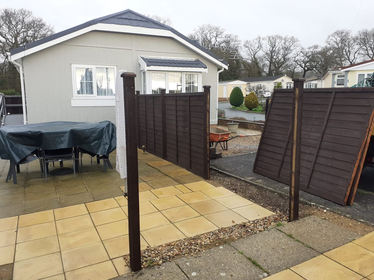 Home with brown privacy fence, paved patio area, and covered garden furniture