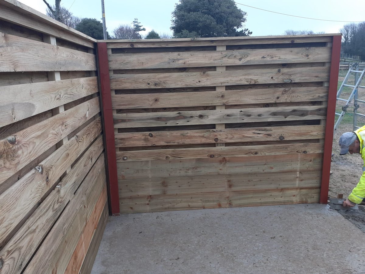 Wooden gate with a steel frame installed at a driveway entrance during construction